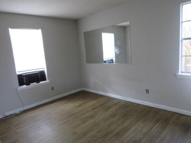 spare room featuring wood finished floors and baseboards