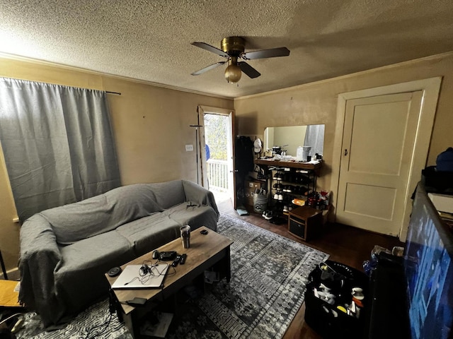 living room featuring a textured ceiling, dark wood-type flooring, ceiling fan, and crown molding