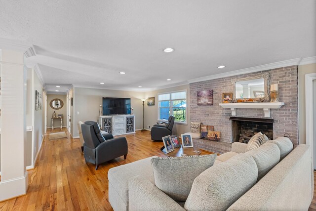 living room featuring crown molding, a brick fireplace, baseboards, light wood-style flooring, and recessed lighting