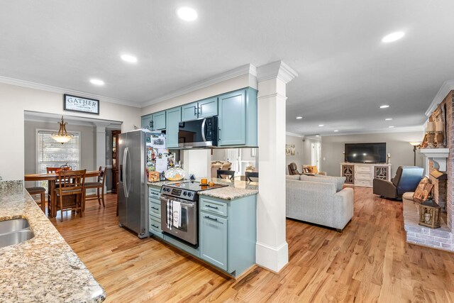kitchen with stainless steel appliances, ornate columns, blue cabinets, crown molding, and light wood-style flooring