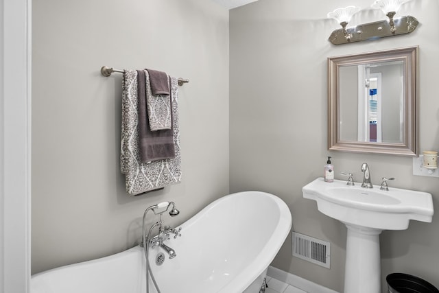 bathroom featuring a freestanding tub and baseboards