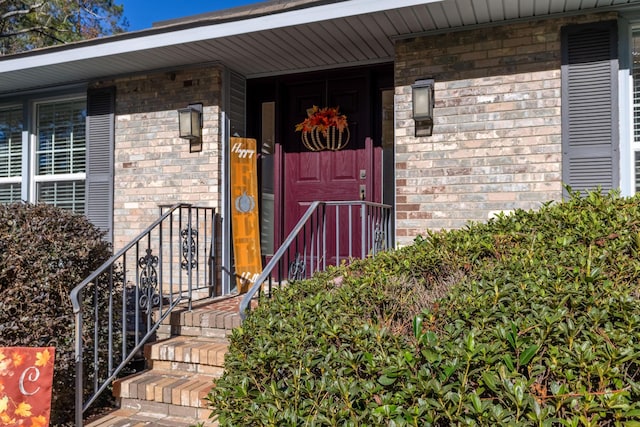 entrance to property featuring brick siding