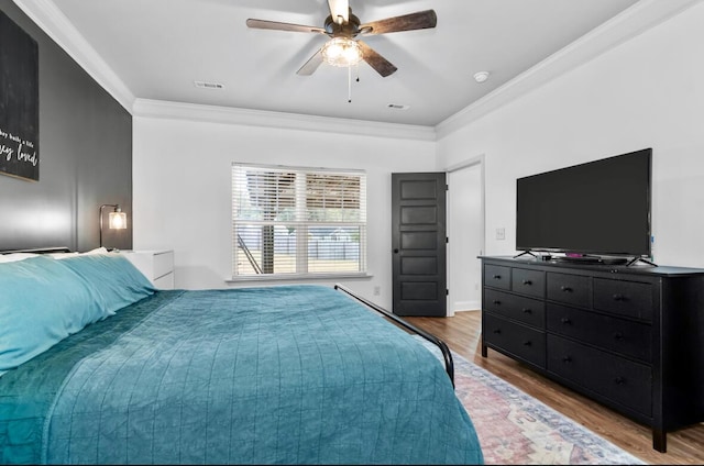 bedroom featuring hardwood / wood-style flooring, ceiling fan, and ornamental molding