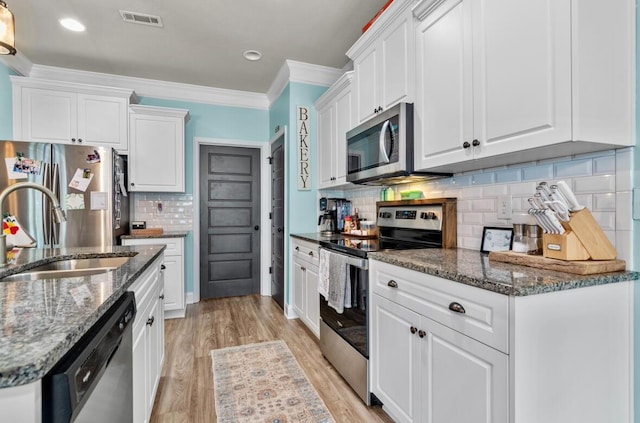 kitchen with white cabinets, appliances with stainless steel finishes, light wood-type flooring, and sink