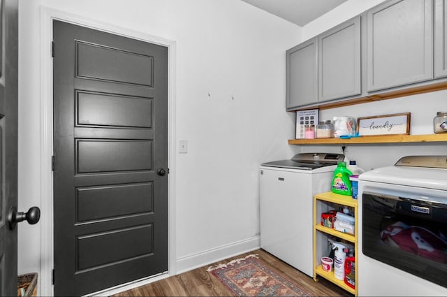 washroom with washer and clothes dryer, cabinets, and dark hardwood / wood-style floors