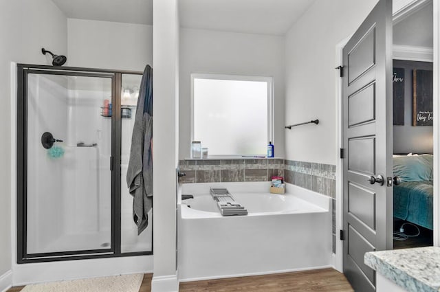 bathroom with hardwood / wood-style floors and separate shower and tub