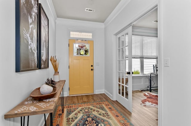 foyer entrance featuring dark hardwood / wood-style flooring, crown molding, and french doors