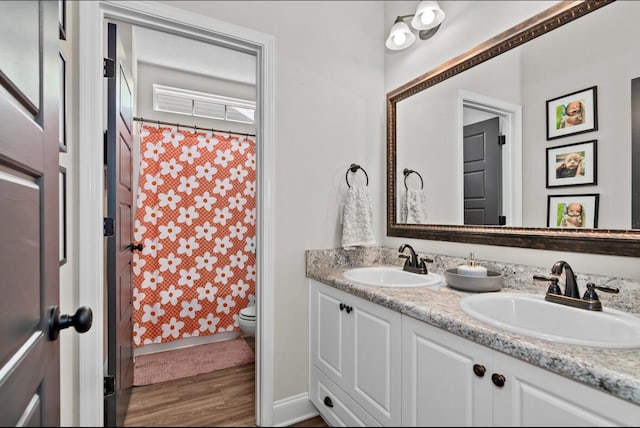 bathroom with a shower with curtain, vanity, hardwood / wood-style flooring, and toilet