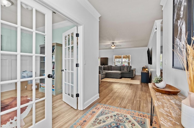 corridor featuring french doors, crown molding, and light hardwood / wood-style flooring