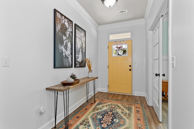 foyer entrance with wood-type flooring and crown molding