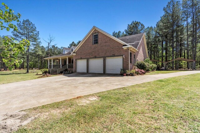 view of front facade featuring covered porch, a garage, and a front yard