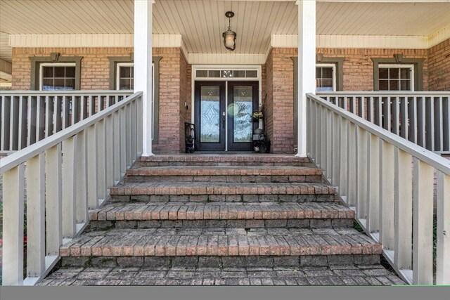 view of exterior entry with french doors and covered porch