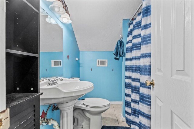 bathroom featuring tile patterned flooring, a shower with shower curtain, vaulted ceiling, and toilet