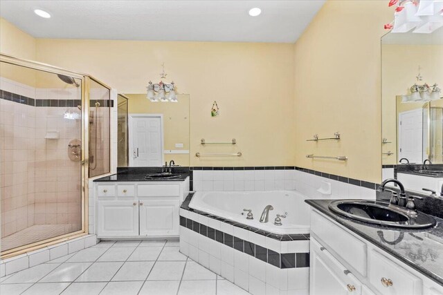 bathroom featuring tile patterned flooring, vanity, and shower with separate bathtub