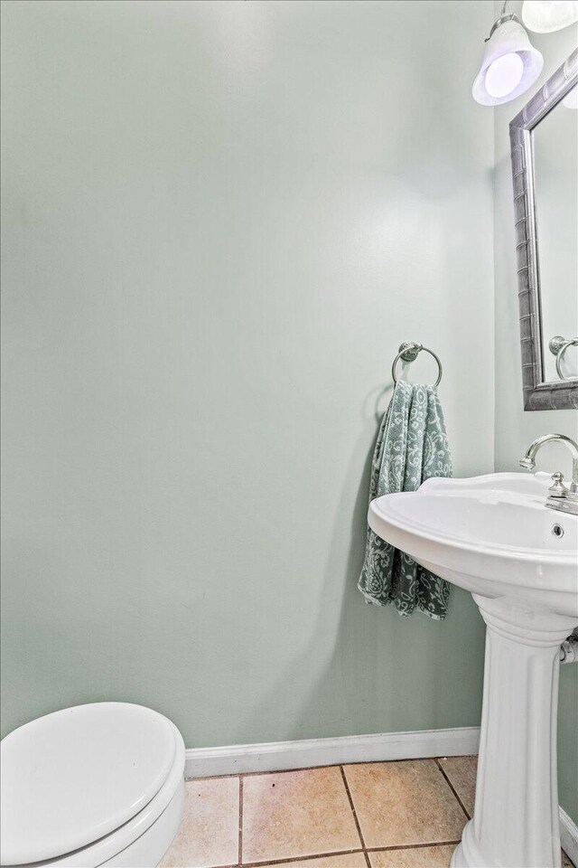 bathroom with toilet and tile patterned floors