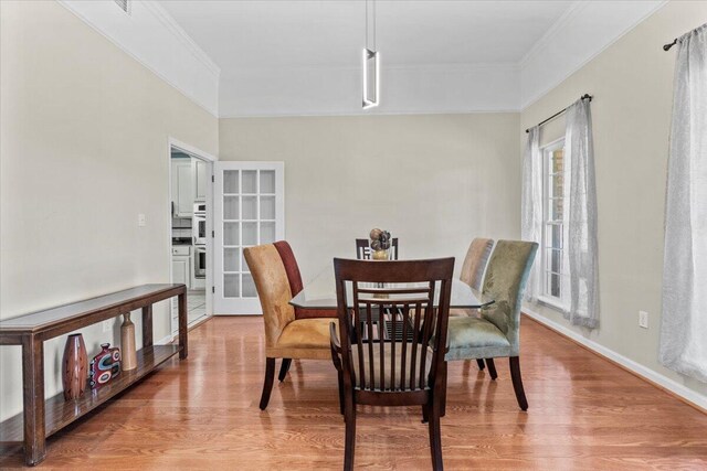 dining area featuring hardwood / wood-style floors, french doors, and ornamental molding