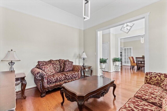 living room with light hardwood / wood-style floors and a notable chandelier