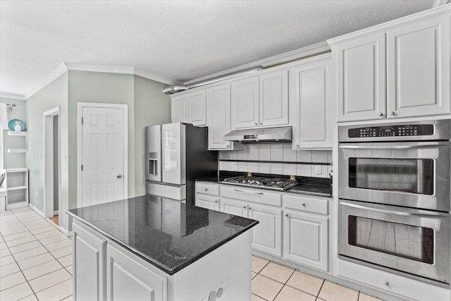 kitchen featuring white cabinetry, a center island, stainless steel appliances, decorative backsplash, and light tile patterned flooring