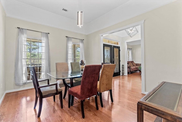 dining area featuring light hardwood / wood-style floors, french doors, and an inviting chandelier