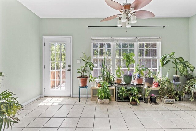 unfurnished sunroom featuring ceiling fan