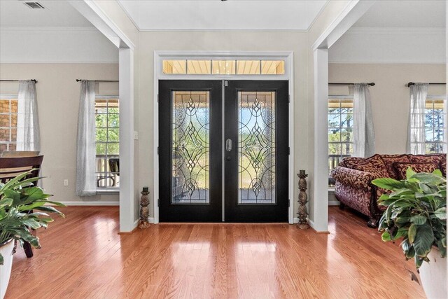 entrance foyer featuring french doors, light hardwood / wood-style flooring, and crown molding