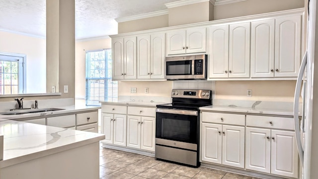 627 Surrey Ln, Martinez, GA 30907 - kitchen with a wealth of natural light, white cabinetry, crown molding, and appliances with stainless steel finishes