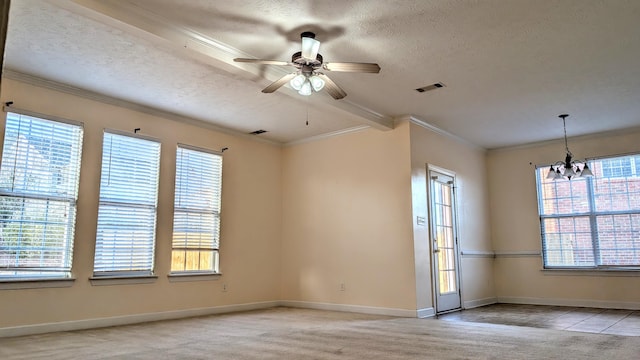 unfurnished room featuring a wealth of natural light, carpet, visible vents, and a textured ceiling