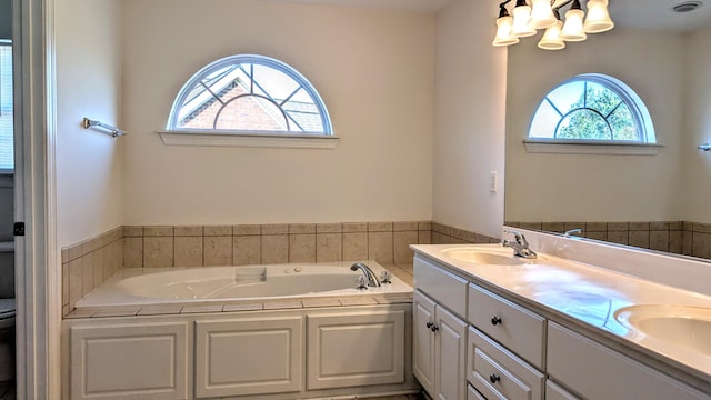 bathroom featuring double vanity, a sink, toilet, and a bath