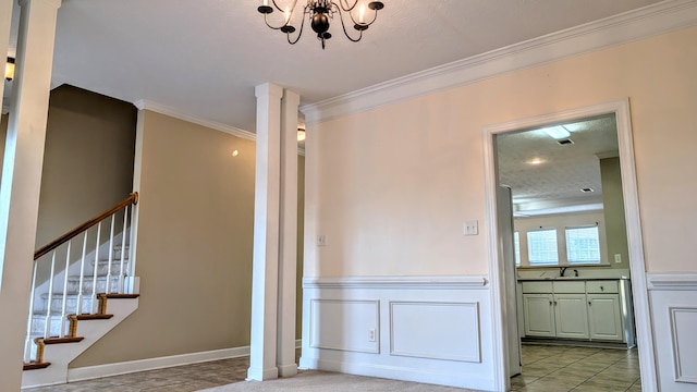 interior space with a chandelier, crown molding, a sink, stairway, and ornate columns