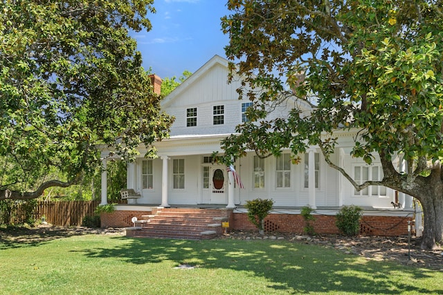 modern inspired farmhouse with a porch, fence, and a front yard