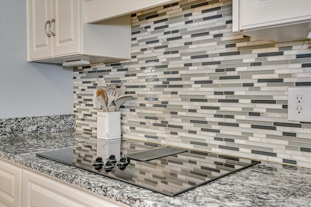 210 Oleander Trl, Evans, GA 30809 - kitchen view of black electric stovetop, tasteful backsplash, and light stone countertops