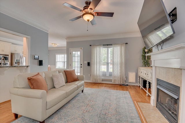 210 Oleander Trl, Evans, GA 30809 - living area featuring a fireplace, ornamental molding, ceiling fan, and light wood-type flooring