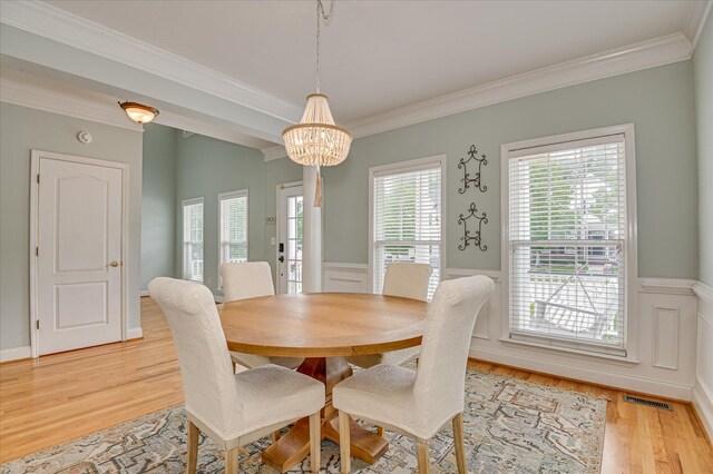 210 Oleander Trl, Evans, GA 30809 - dining room featuring crown molding, a chandelier, light wood-style floors, and wainscoting