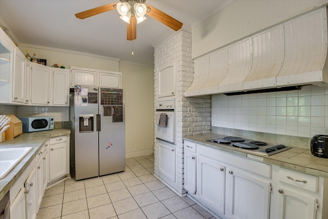 kitchen featuring custom exhaust hood, ornamental molding, tasteful backsplash, white cabinetry, and stainless steel appliances