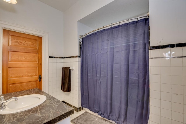 bathroom with vanity, tile walls, and walk in shower