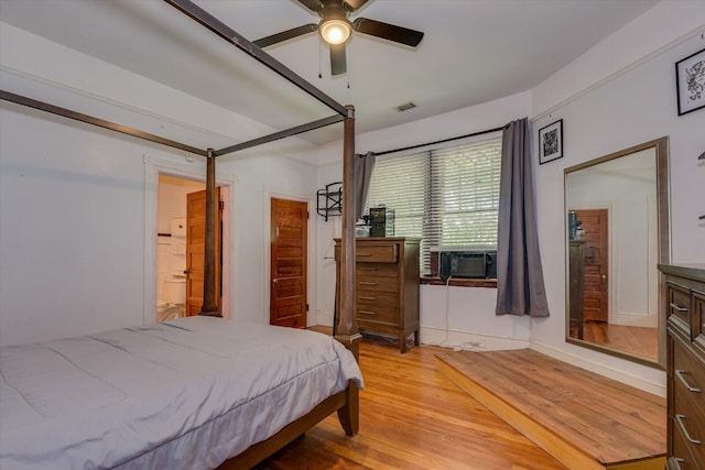 bedroom with hardwood / wood-style floors, ceiling fan, cooling unit, and ensuite bathroom