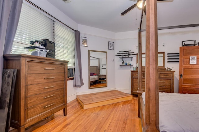 bedroom with multiple windows, ceiling fan, and wood-type flooring