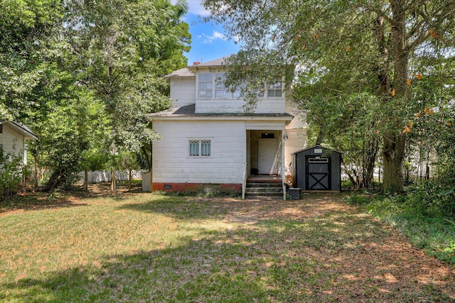 rear view of property with a yard and a shed