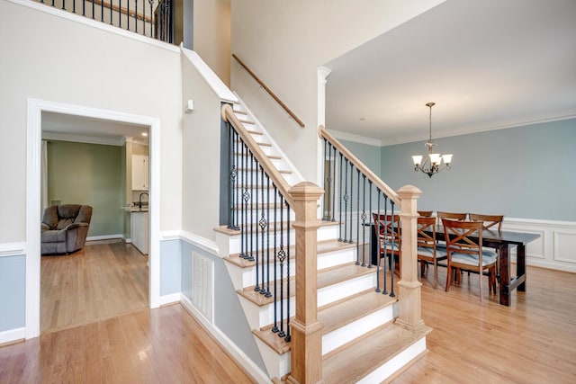 225 Old Mill Rd, Martinez, GA 30907 - stairway featuring wood finished floors, a chandelier, ornamental molding, and wainscoting