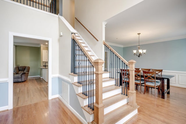 225 Old Mill Rd, Martinez, GA 30907 - staircase with wood finished floors, a chandelier, ornamental molding, and wainscoting