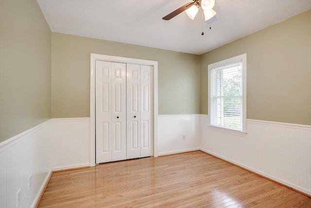 225 Old Mill Rd, Martinez, GA 30907 - unfurnished bedroom featuring a wainscoted wall, light wood-type flooring, a closet, and ceiling fan