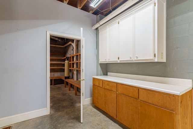 interior space featuring concrete block wall and baseboards