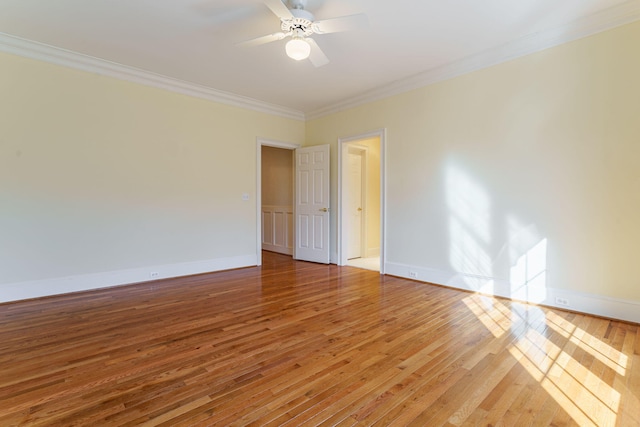 empty room with baseboards, ceiling fan, ornamental molding, and wood finished floors