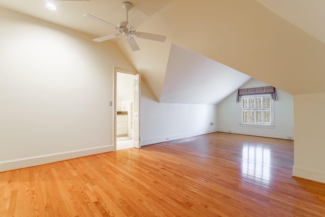 additional living space with light wood-style floors, lofted ceiling, ceiling fan, and baseboards