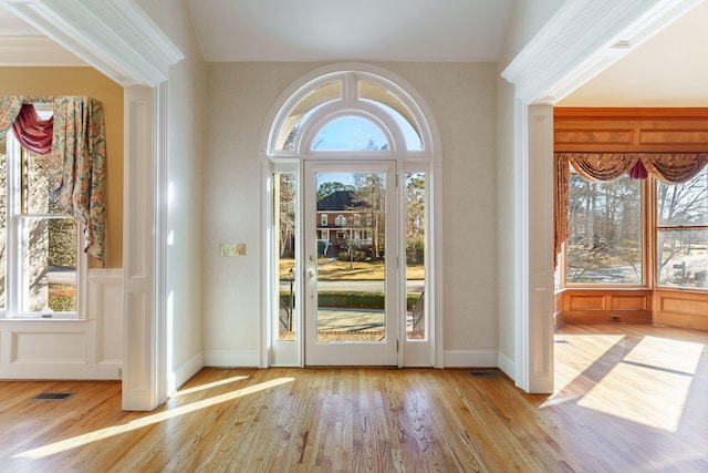 doorway with light wood-type flooring, a healthy amount of sunlight, and visible vents