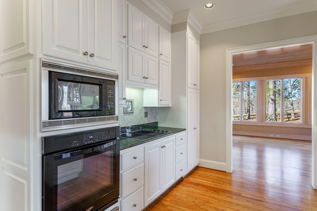 kitchen with black appliances, white cabinetry, backsplash, and ornamental molding