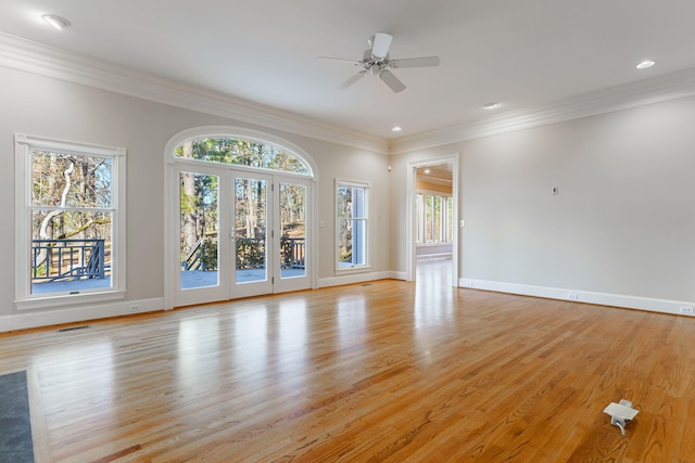 unfurnished living room with light wood-style floors, baseboards, and crown molding