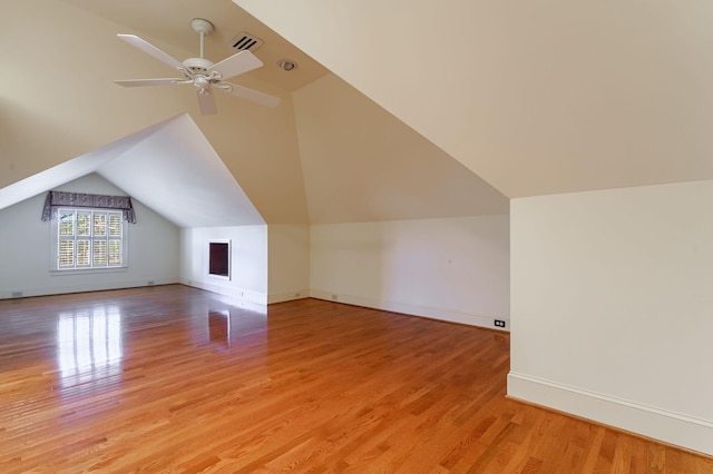 bonus room featuring ceiling fan, light wood-style flooring, baseboards, and vaulted ceiling