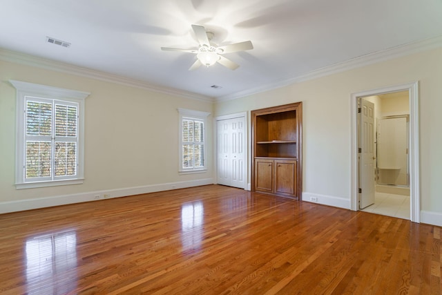 unfurnished bedroom featuring ornamental molding, visible vents, and light wood-style flooring