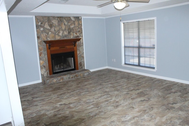 unfurnished living room featuring ceiling fan, a fireplace, and crown molding